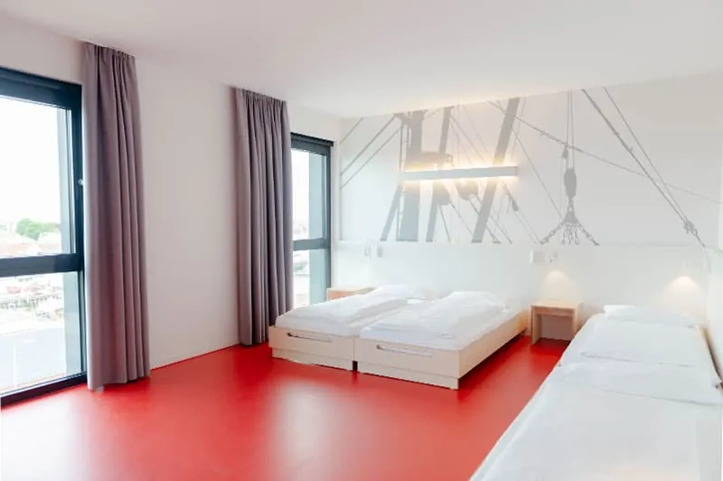 Helles Mehrbettzimmer mit großem Fenster